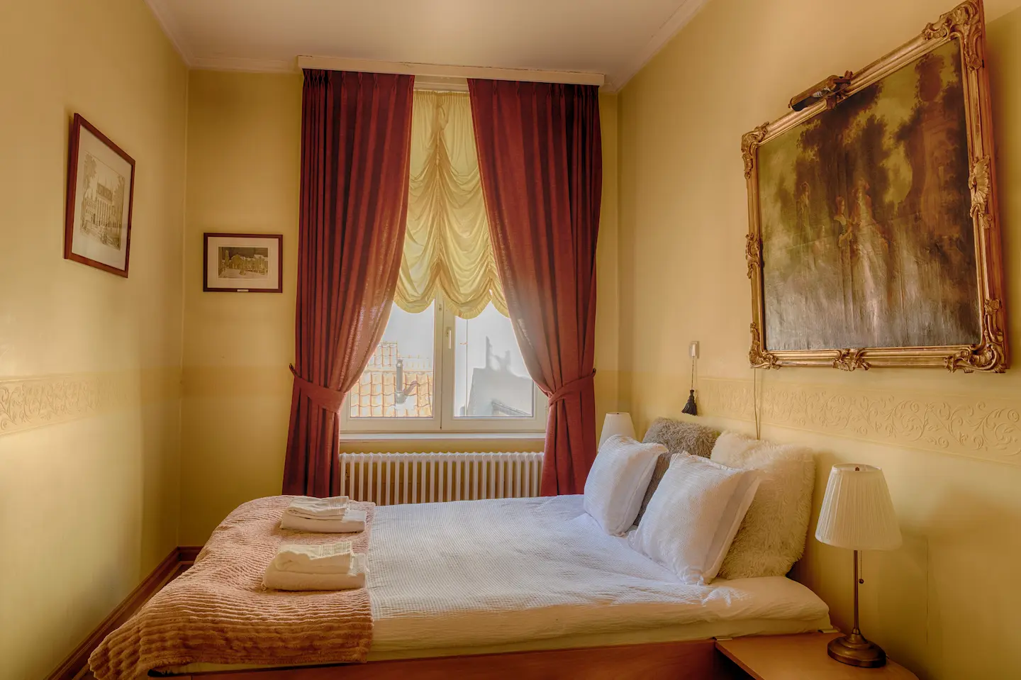 Bed met warme gordijnen en klassiek schilderij