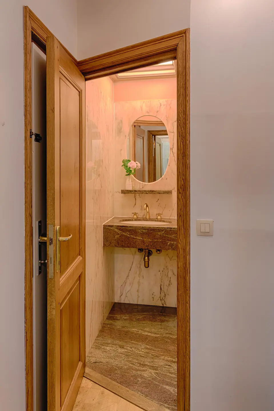 Doorkijk naar compacte badkamer met marmer